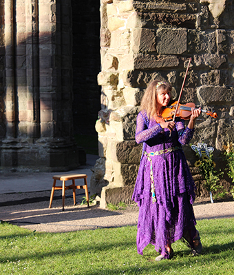 Fiona playing the violin in Tintern abbey